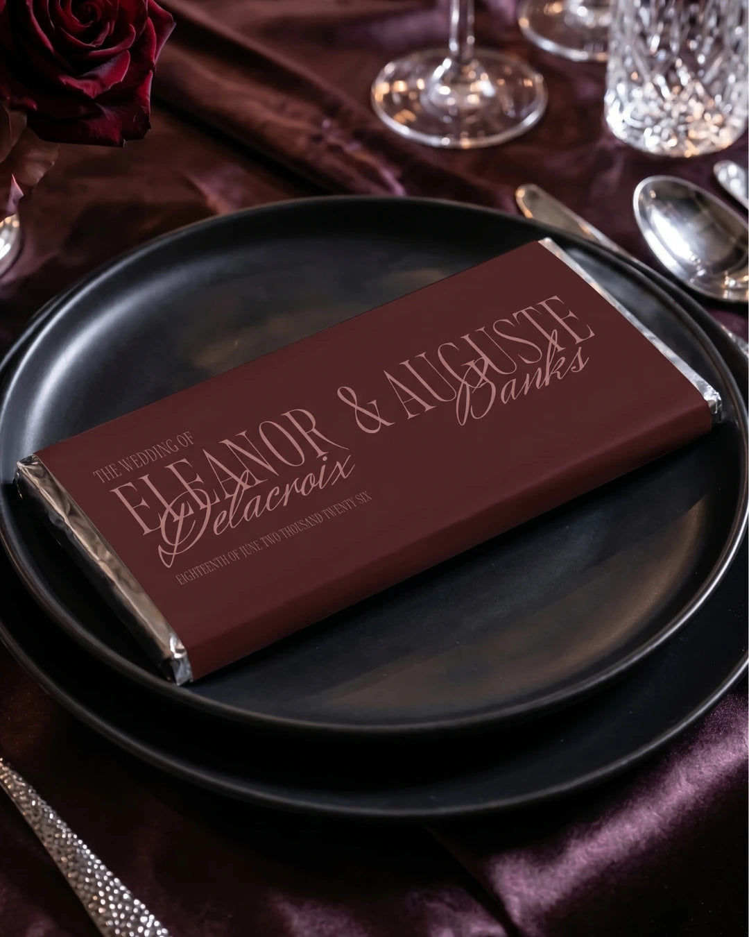 Burgundy personalised wedding favour chocolate bar styled on matte black plate with crystal glassware and silk tablecloth, Australia