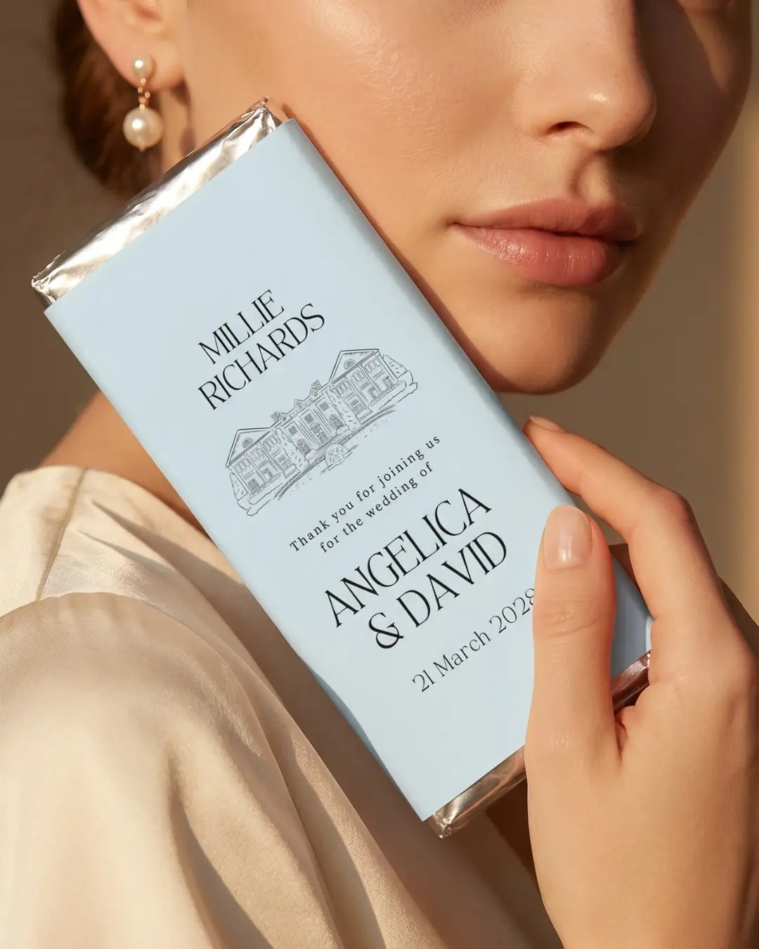 Woman holding a personalised chocolate bar wedding favour with custom venue illustration and luxury wedding design